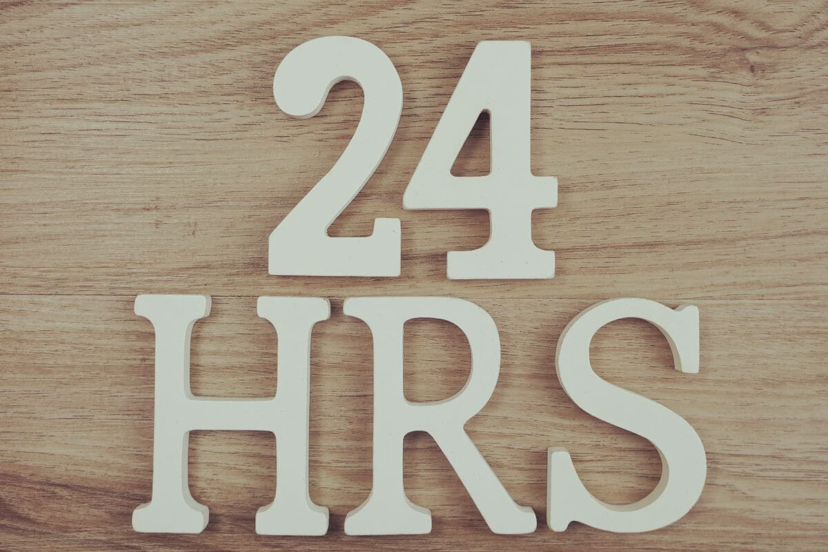 A picture shows a 24-hour wording on a wooden background.