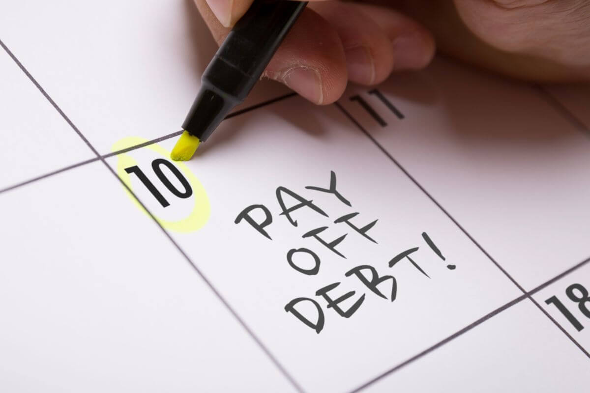 A picture of a woman's hand marking her calendar with notes.