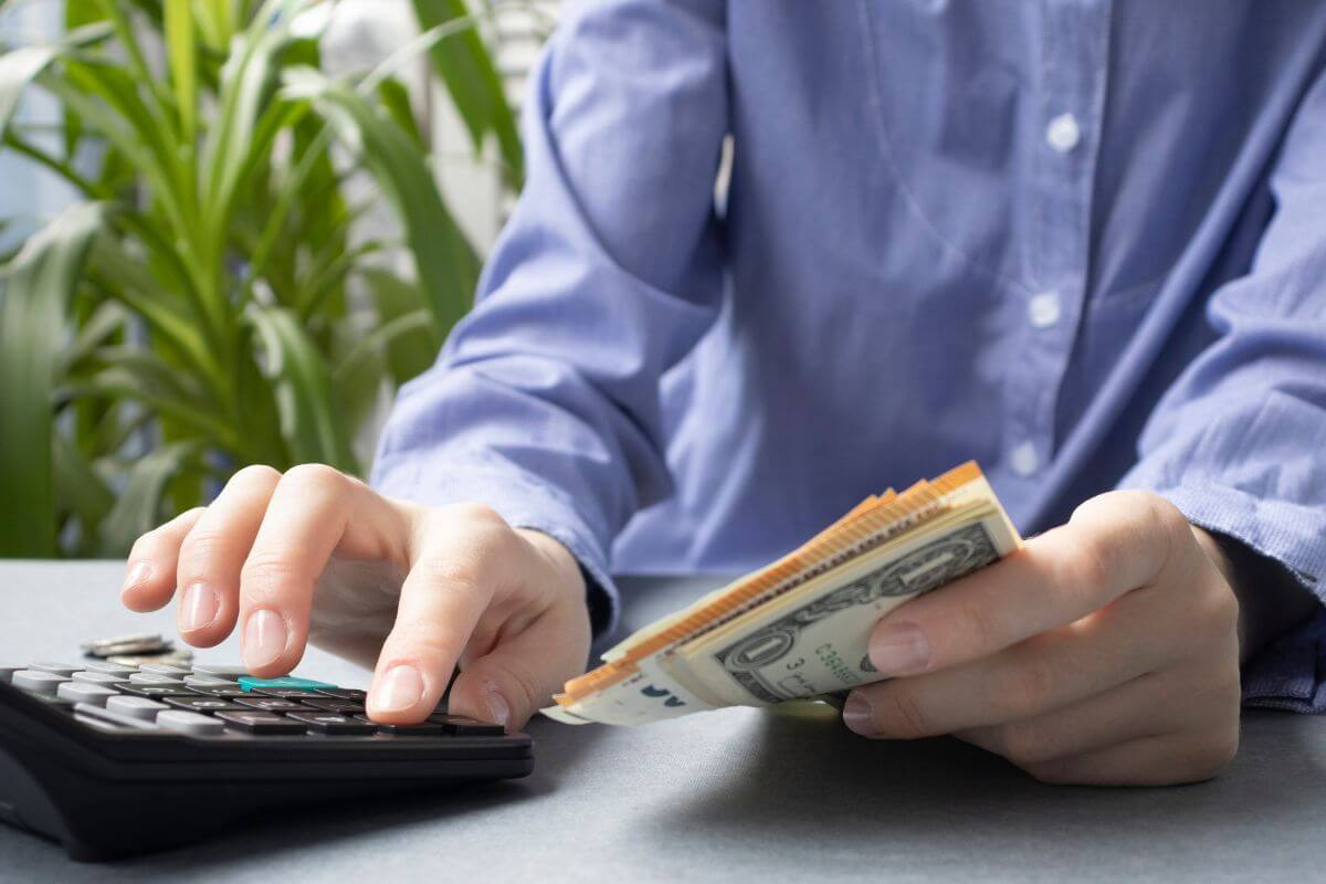 A picture shows a man's hand calculating money,