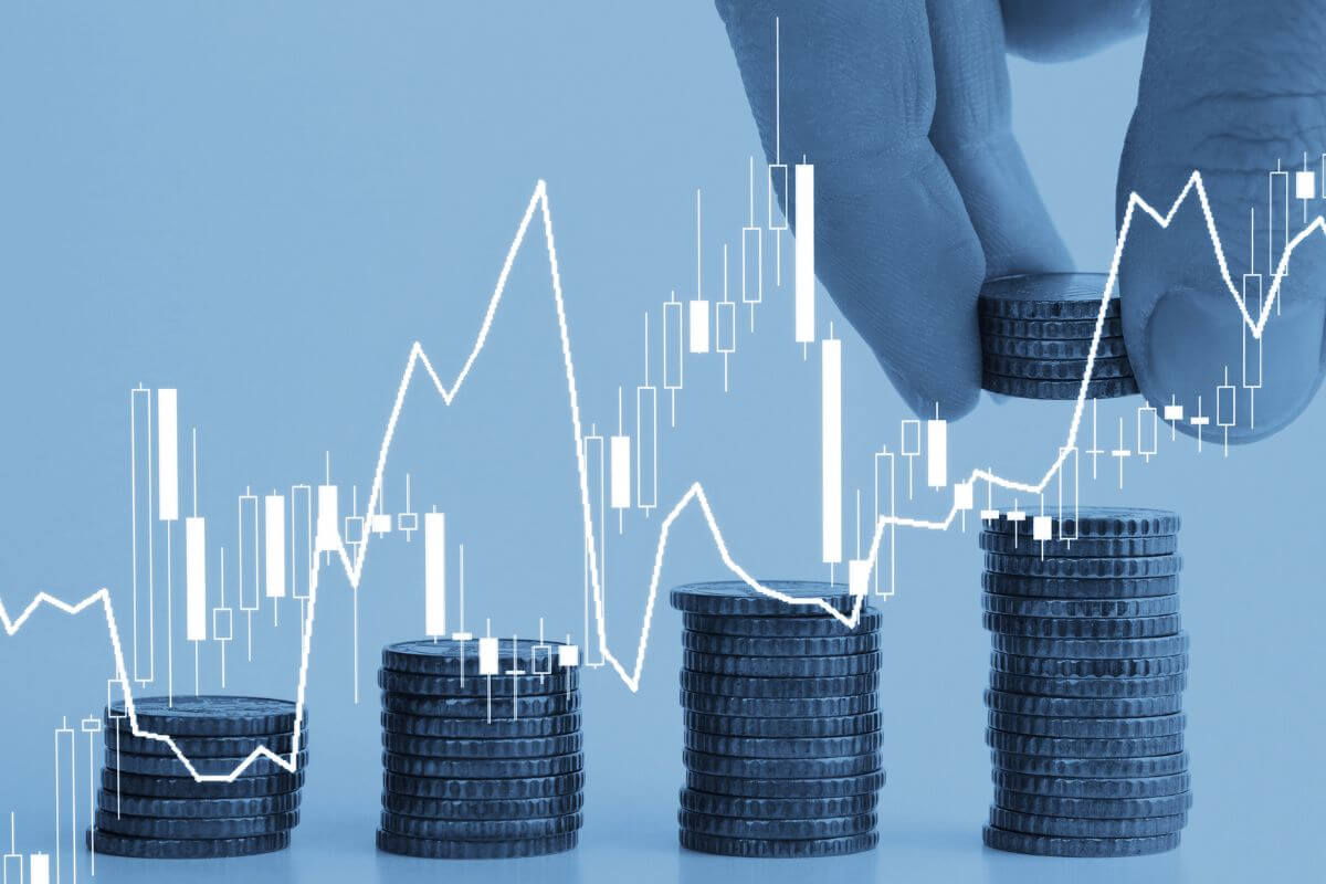 A picture shows a man's hand and stacks of coins.
