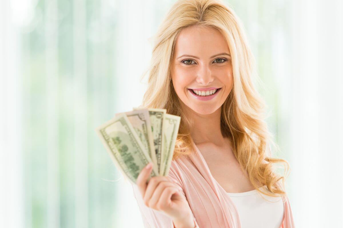 An image of a woman holding money.