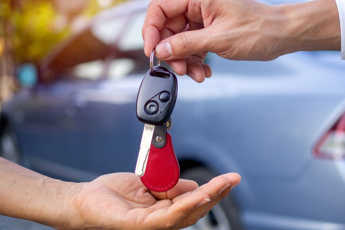 A picture shows a person handing a key car.