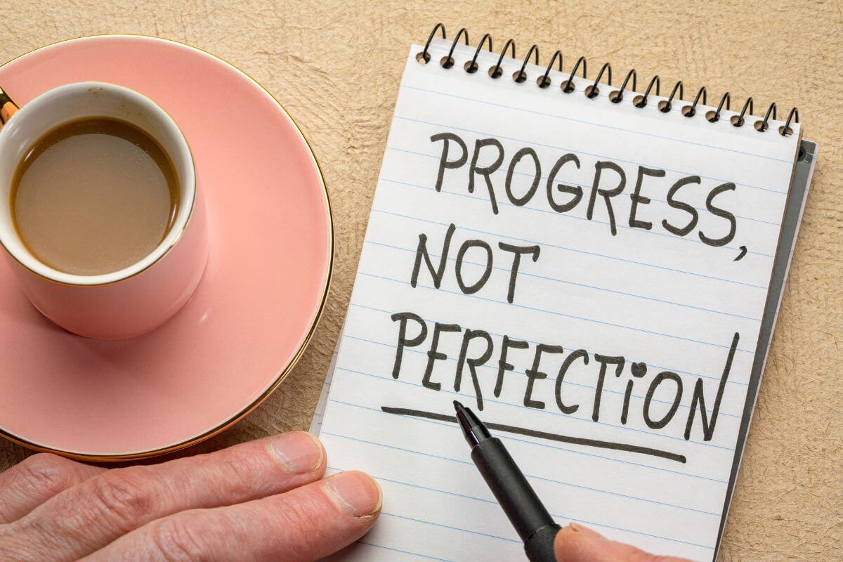 A picture of a man's hand writing something on a paper.