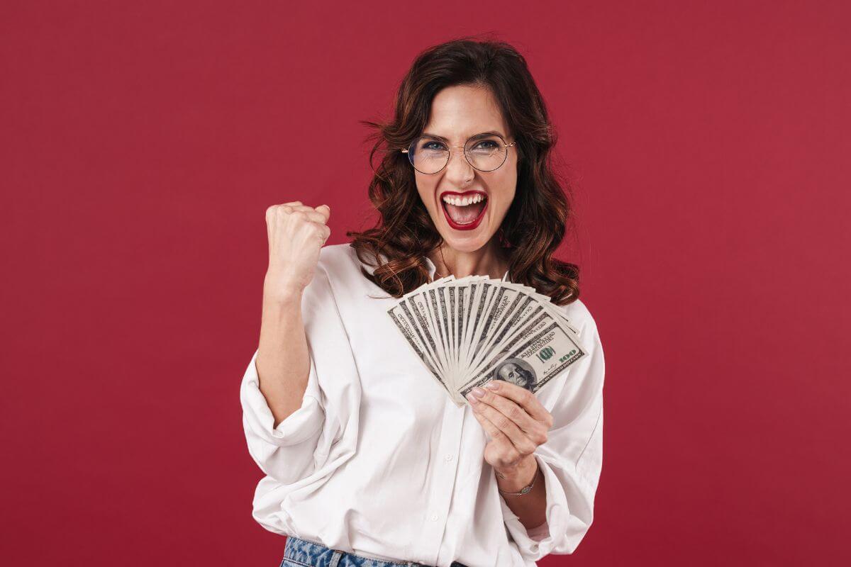 A picture of a happy woman holding money.