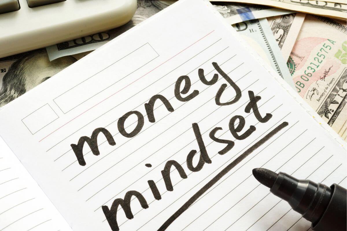 An image shows a notebook with money mindset wording.