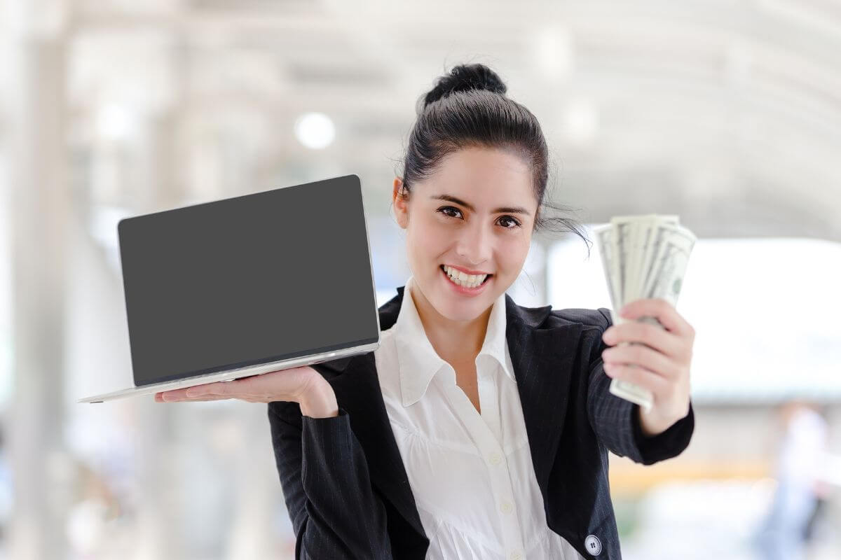 Une femme avec un ordinateur portable et de l'argent.