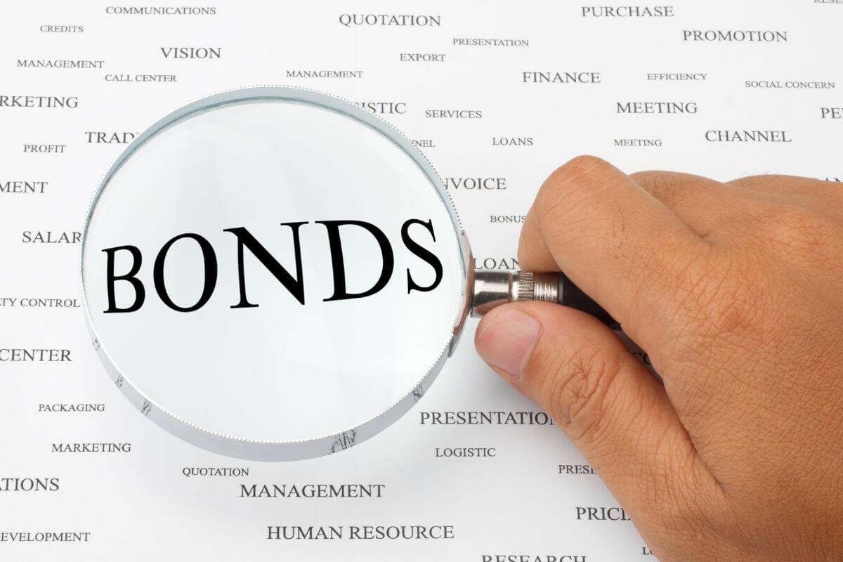 A picture of a man's hand magnifying the word bonds.