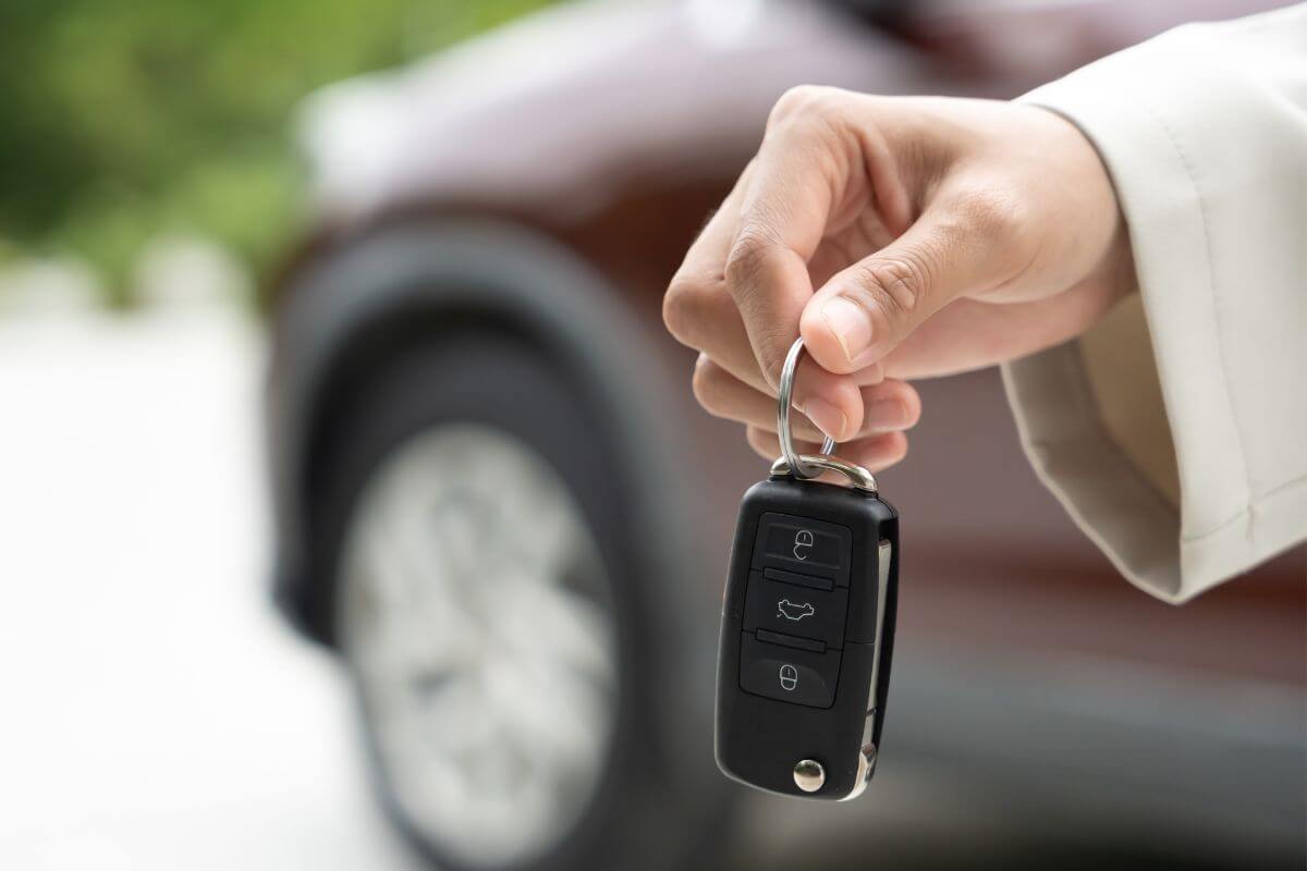 Une main d'homme tenant une clé de voiture.