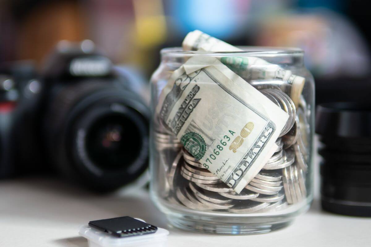 Un bocal rempli d'argent et un appareil photo.