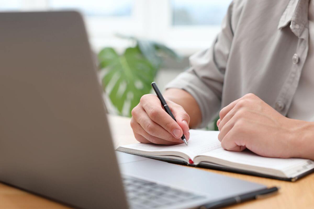 A picture of a man writing in a notebook.