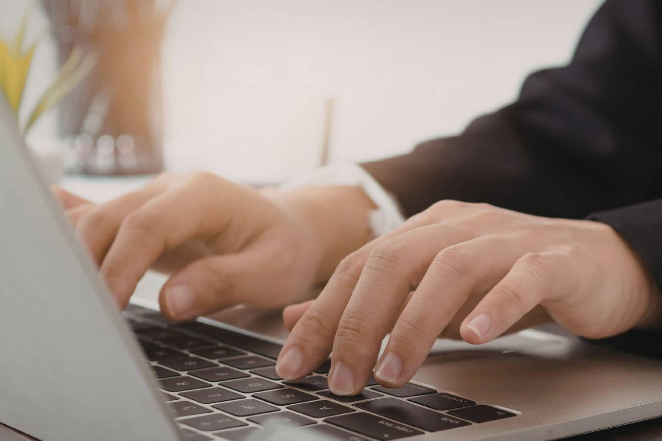 A picture shows a man's hand using a laptop.