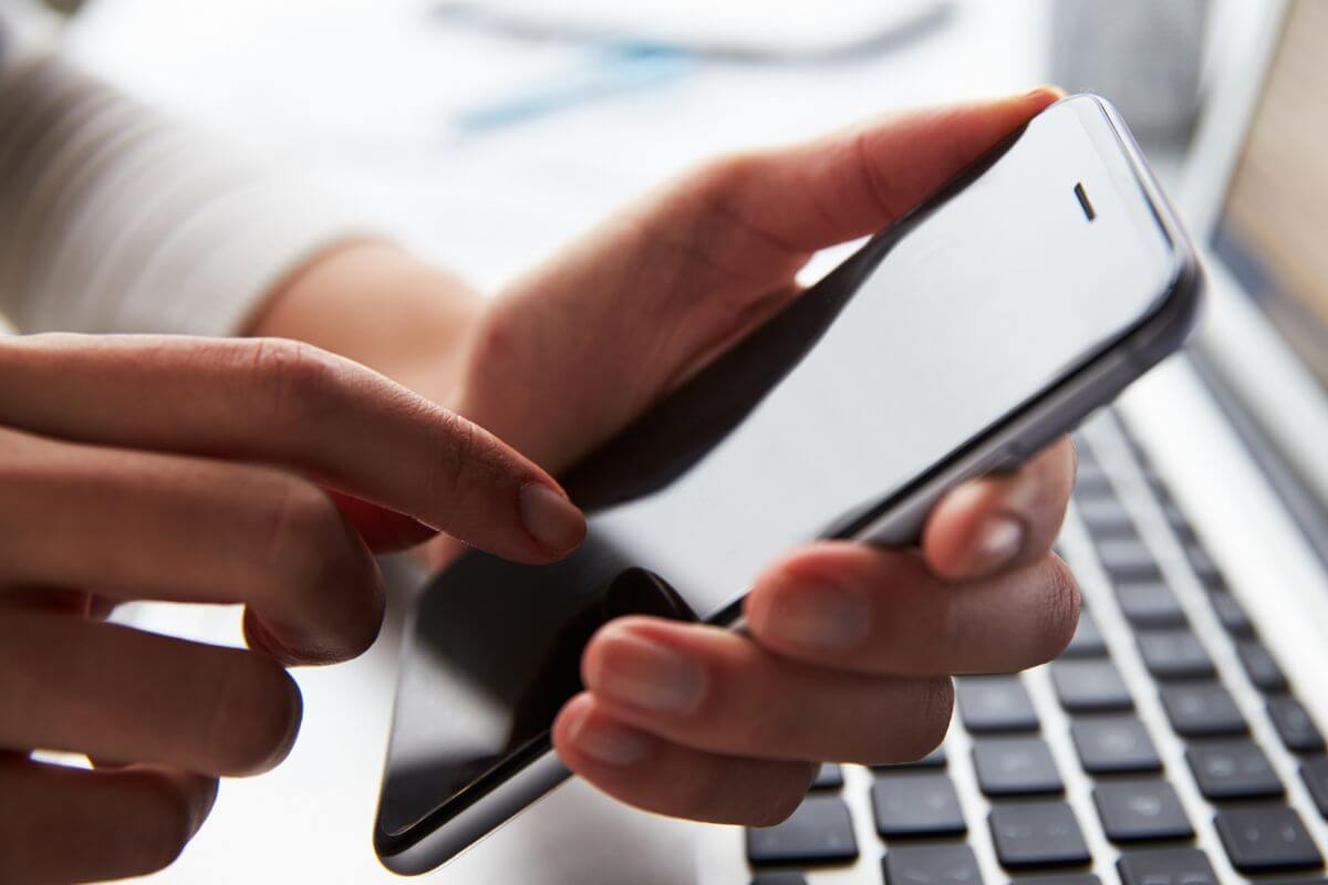 A picture of a woman's hand using a phone.