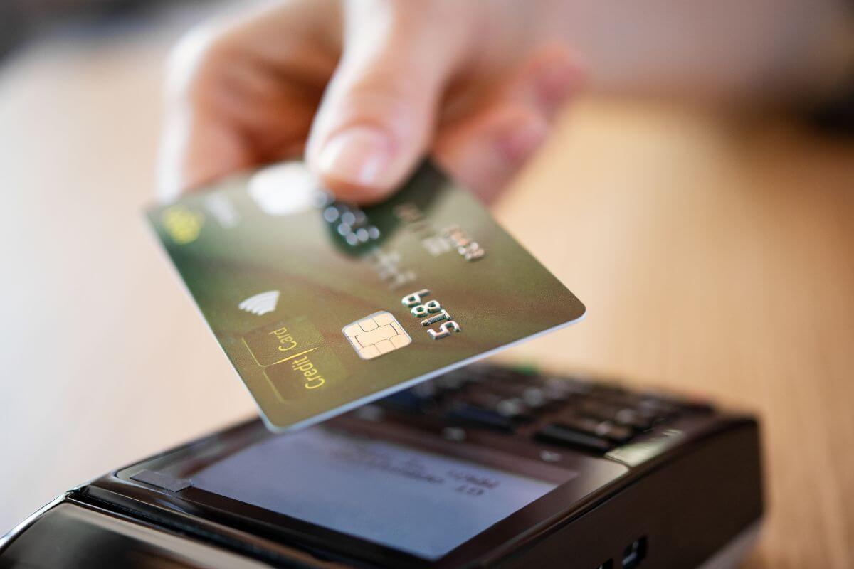 A picture of a woman's hand using a credit card.