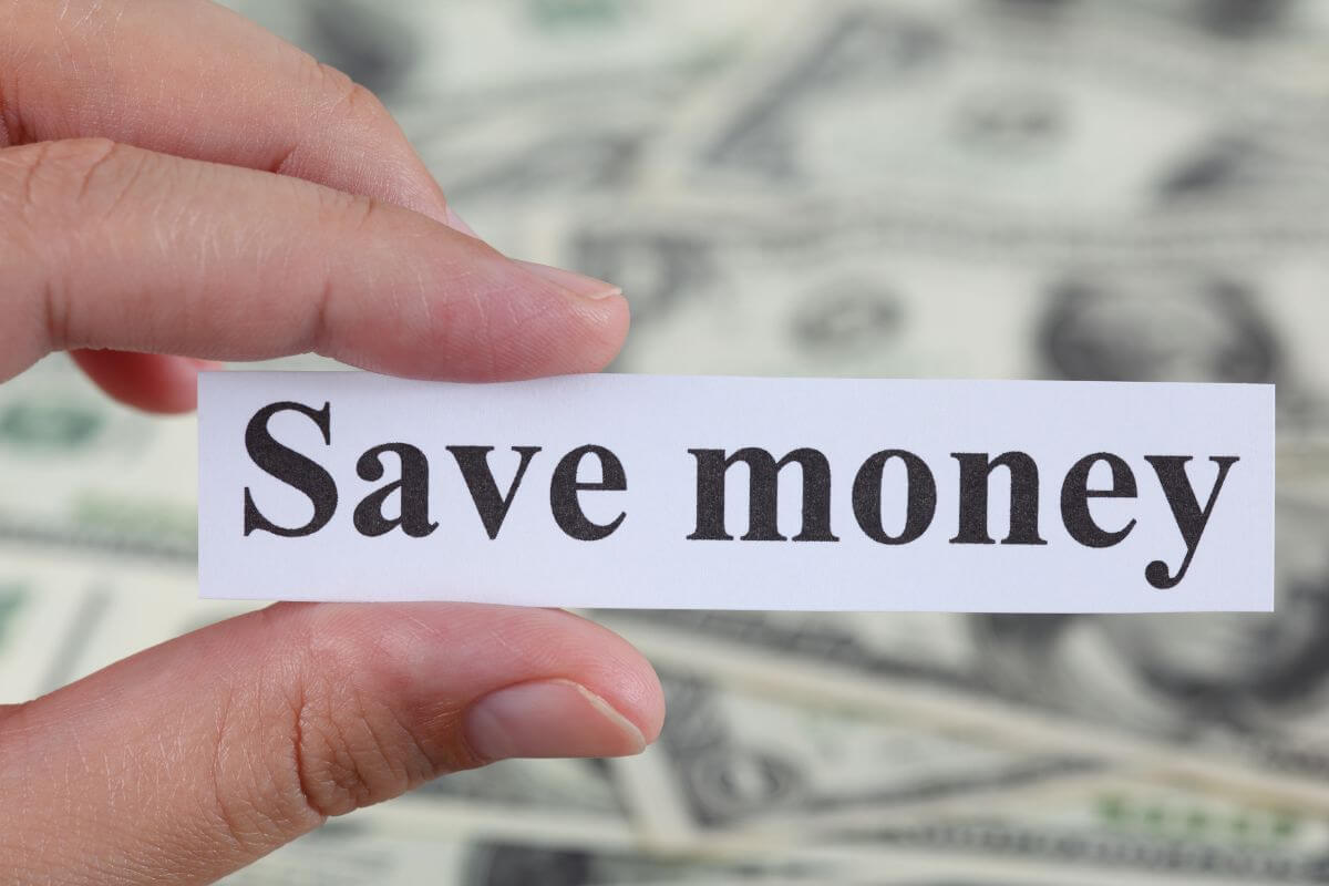 An image of a woman's hand holding a save money paper.