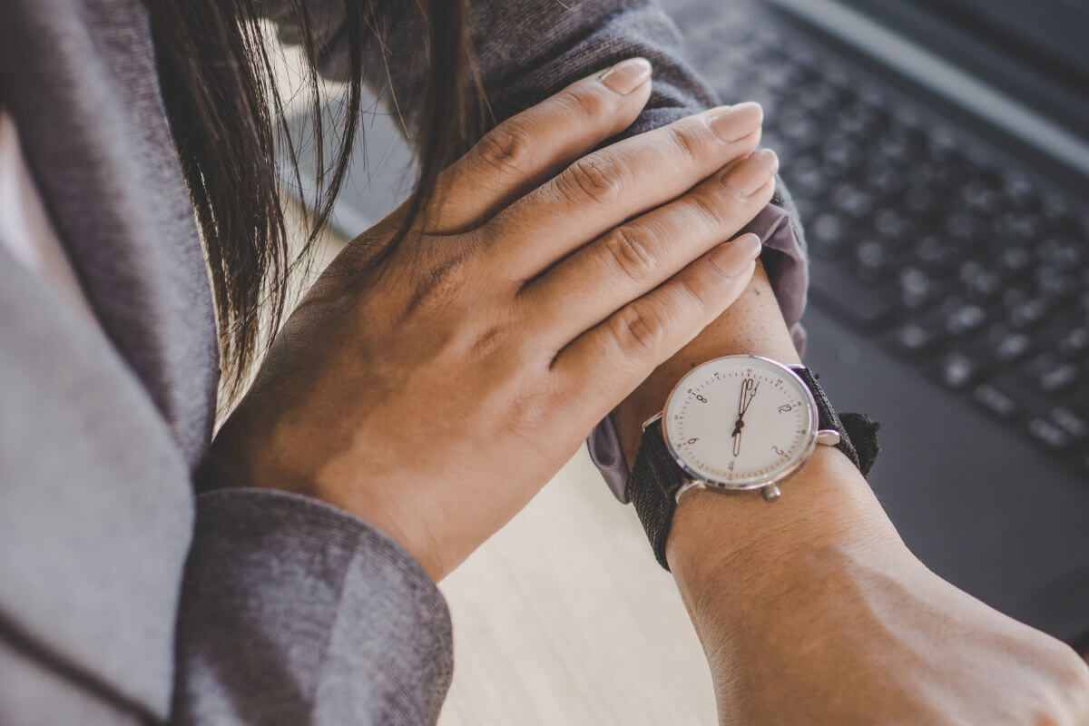 A picture shows a woman checking her watch.