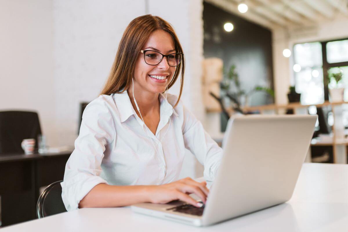 An image shows a woman working on a laptop.