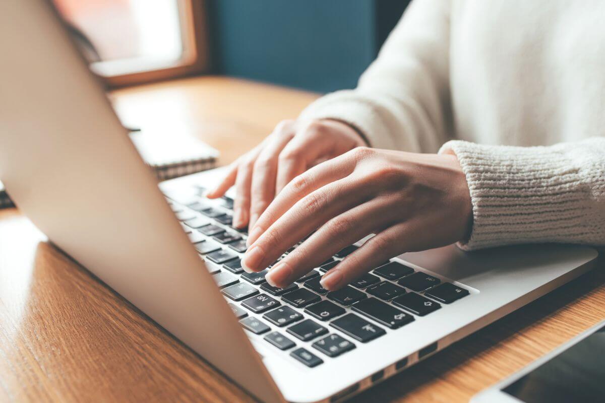 An image of a woman typing on a laptop.