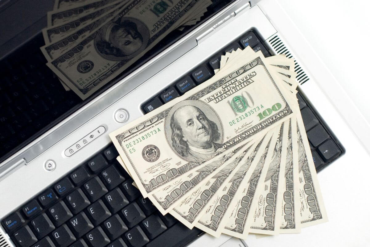 A picture shows a laptop and money.