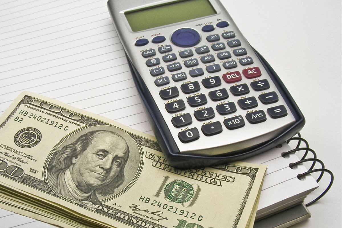 An image of a calculator, money, and a notebook.