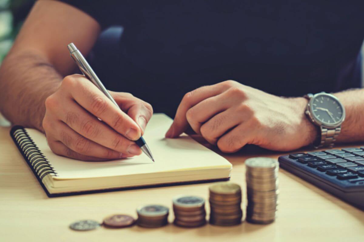 A picture shows a man writing in a notebook.