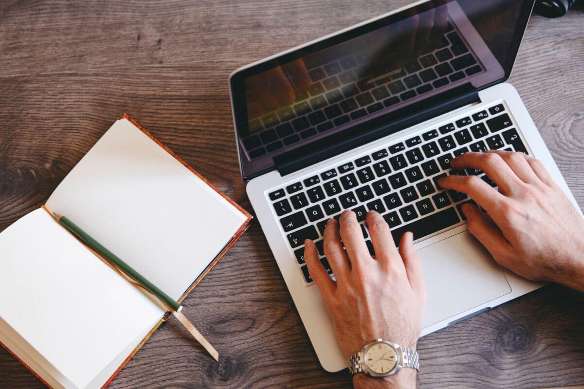 A picture shows a man typing on a laptop.