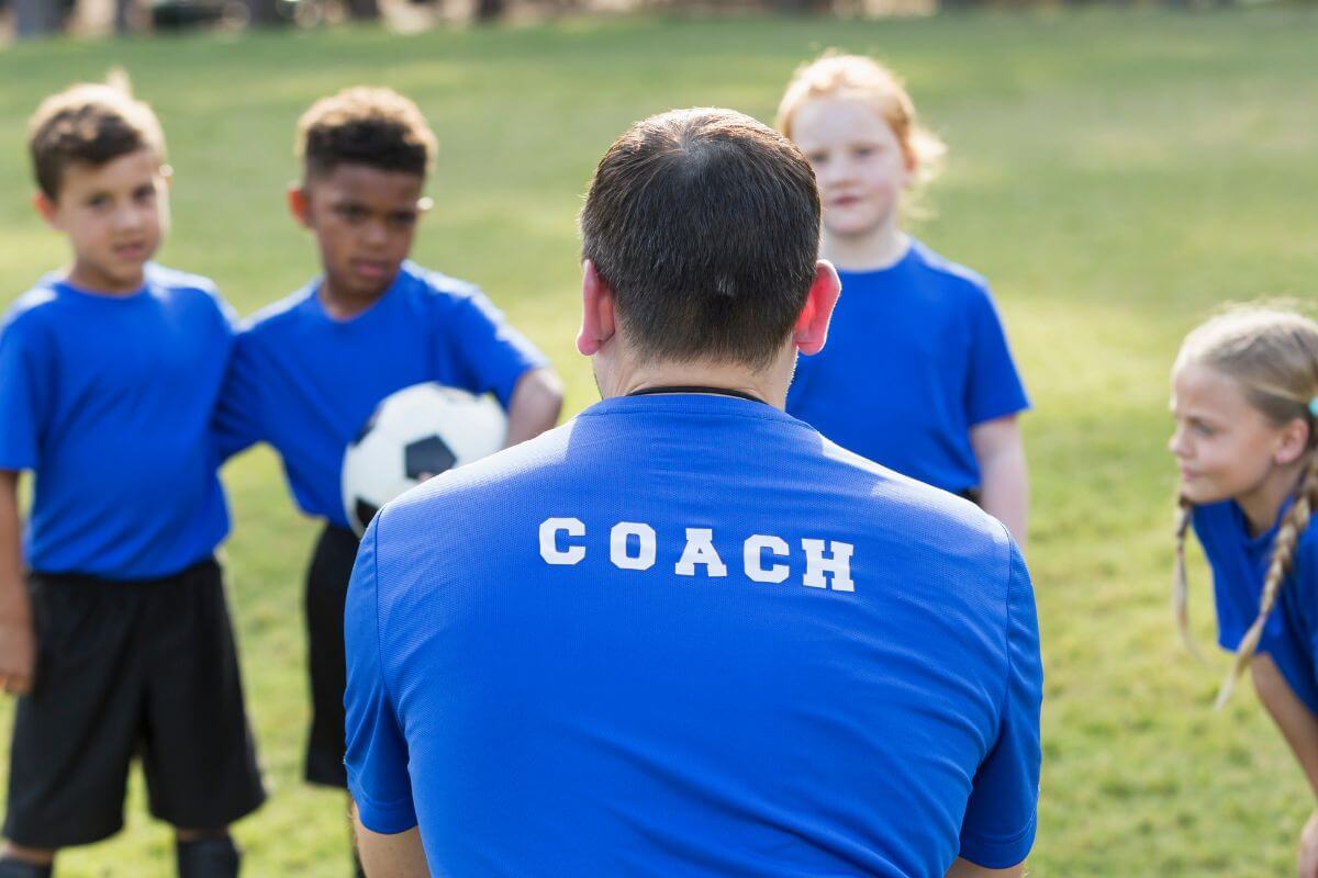 A picture shows a man coaching the kids.