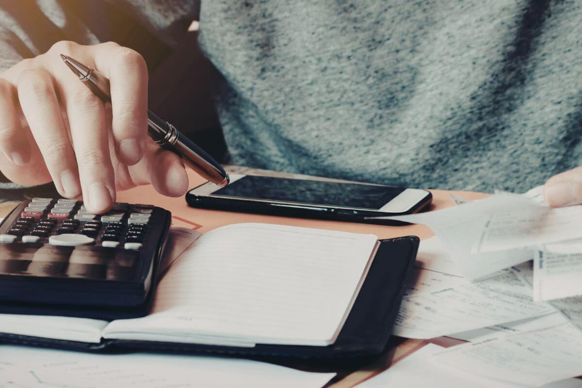 A picture shows a woman calculating her expenses.