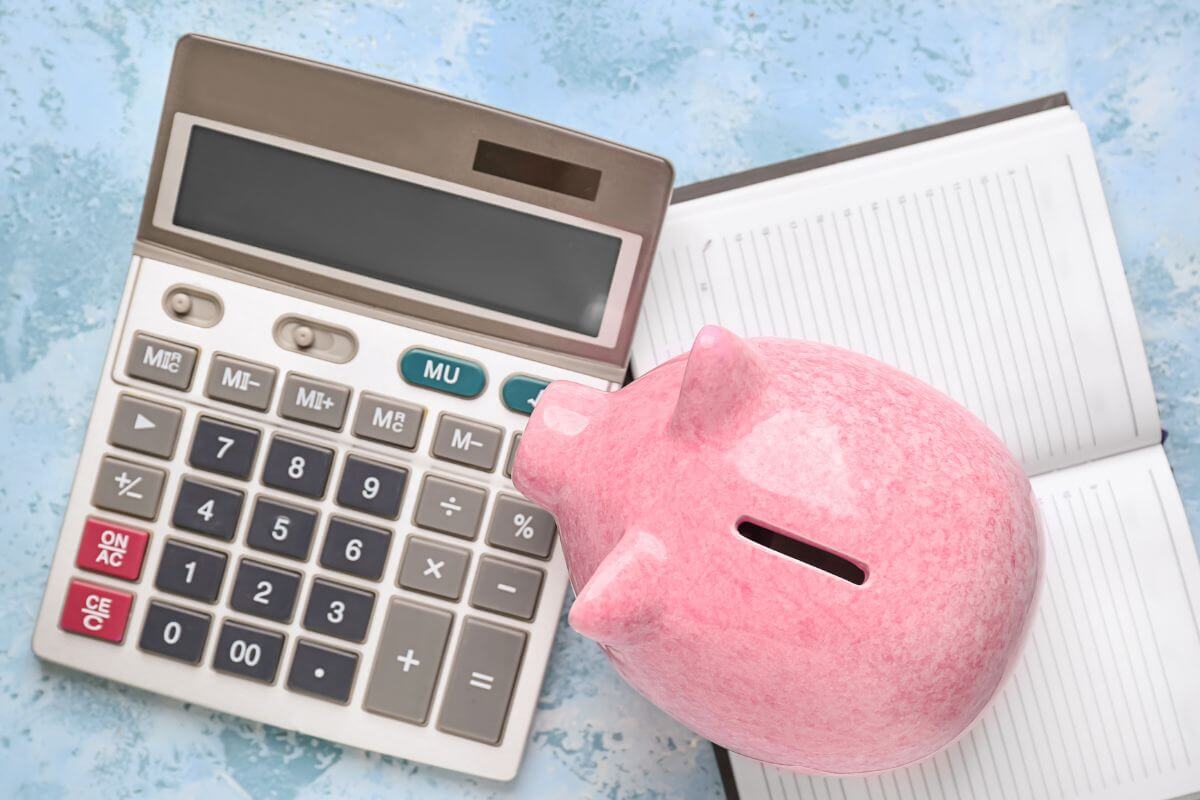 An image shows a piggy bank, a calculator, and a notebook.
