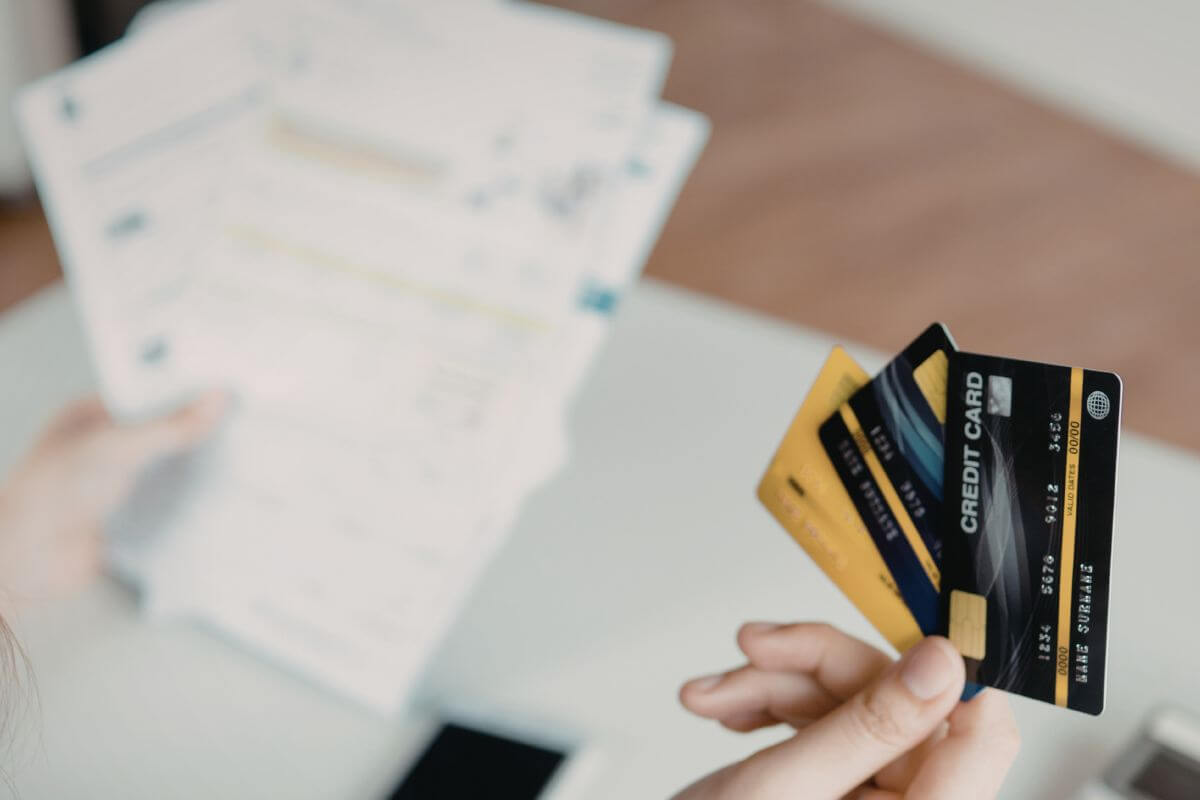 A picture shows a woman holding credit cards and documents.