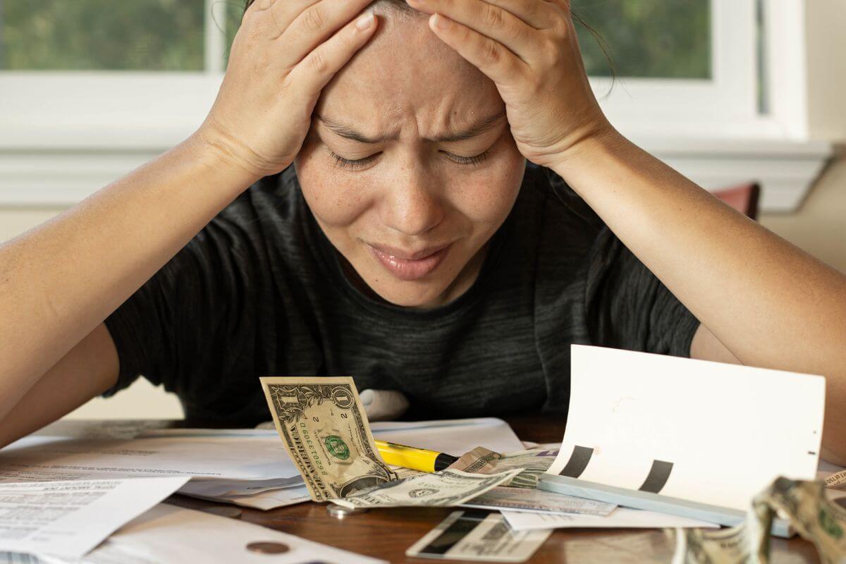 An image shows a stressed woman about her finances.