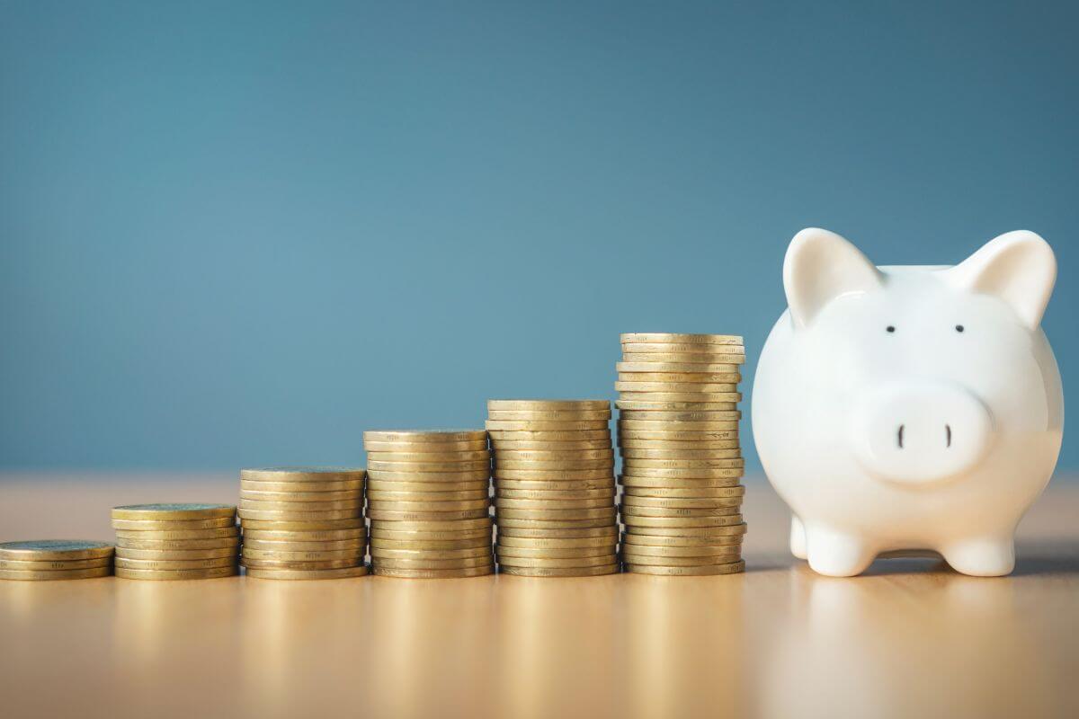 Une image montre des piles de pièces et une tirelire.