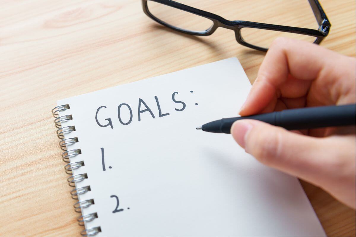 Une image montre une femme écrivant ses objectifs.