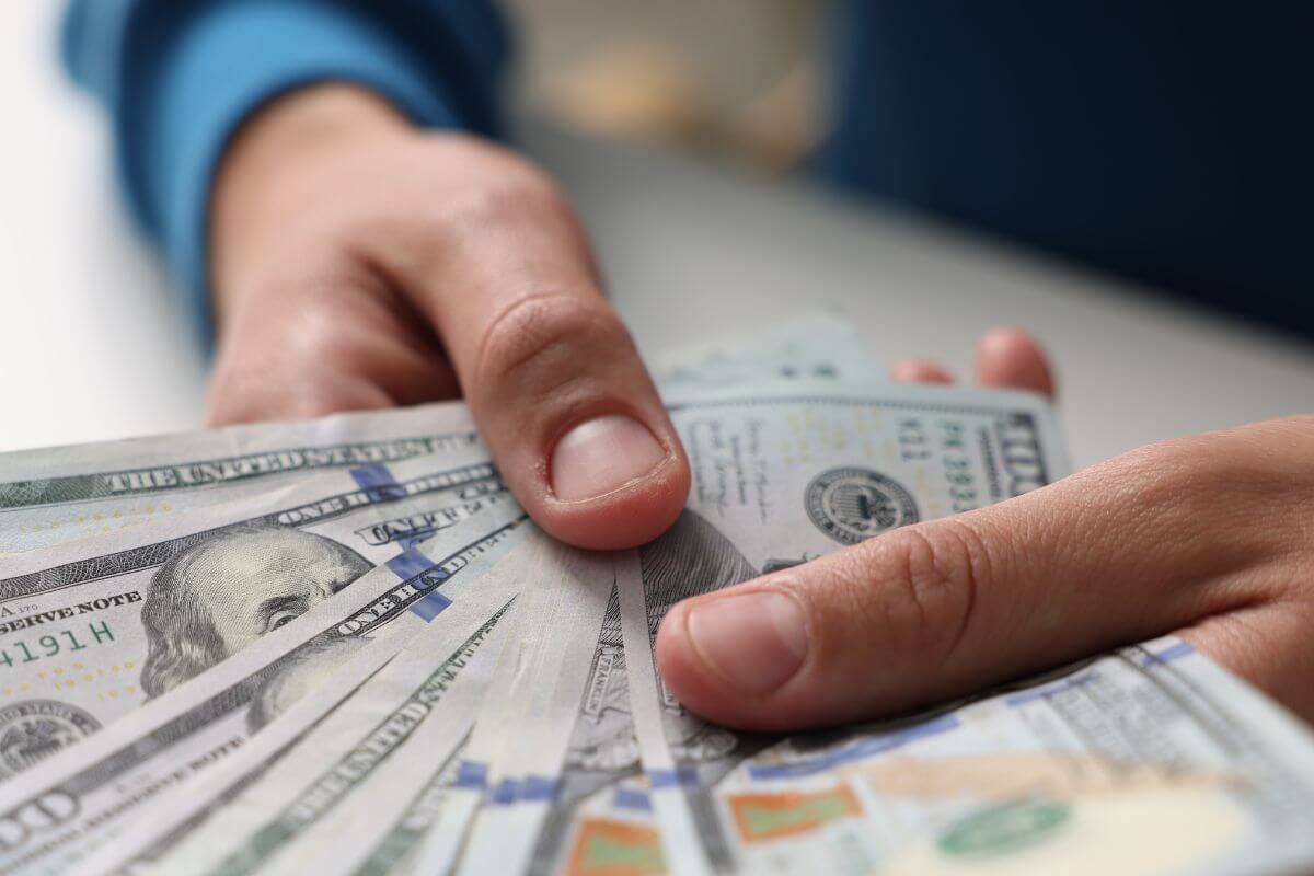 Une image d'une main d'homme tenant de l'argent.