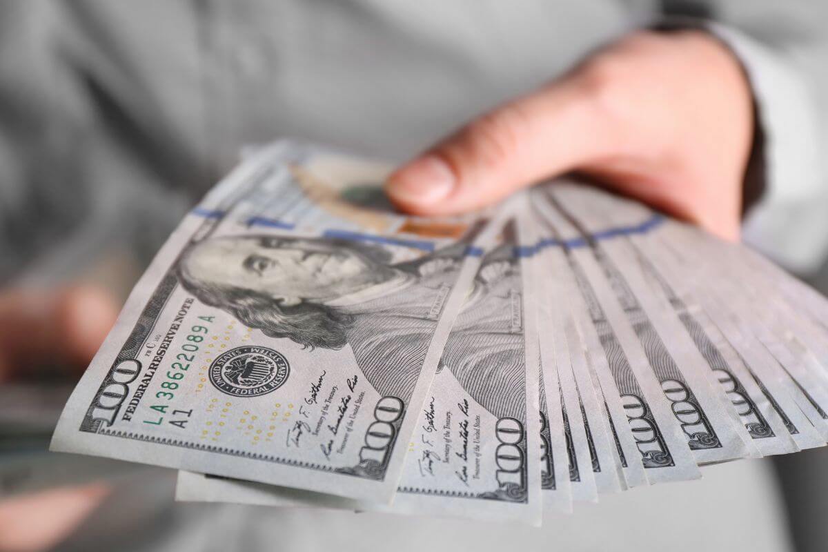 A picture shows a woman's hand holding money.