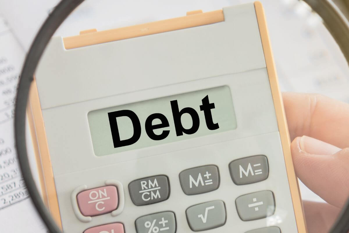 An image shows a calculator with debt wording.