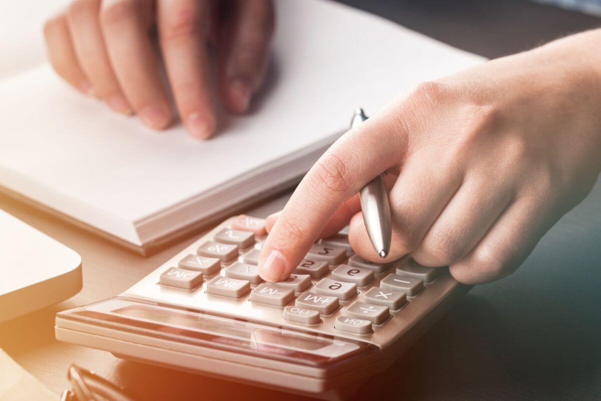 An image shows a woman's hand calculating something.