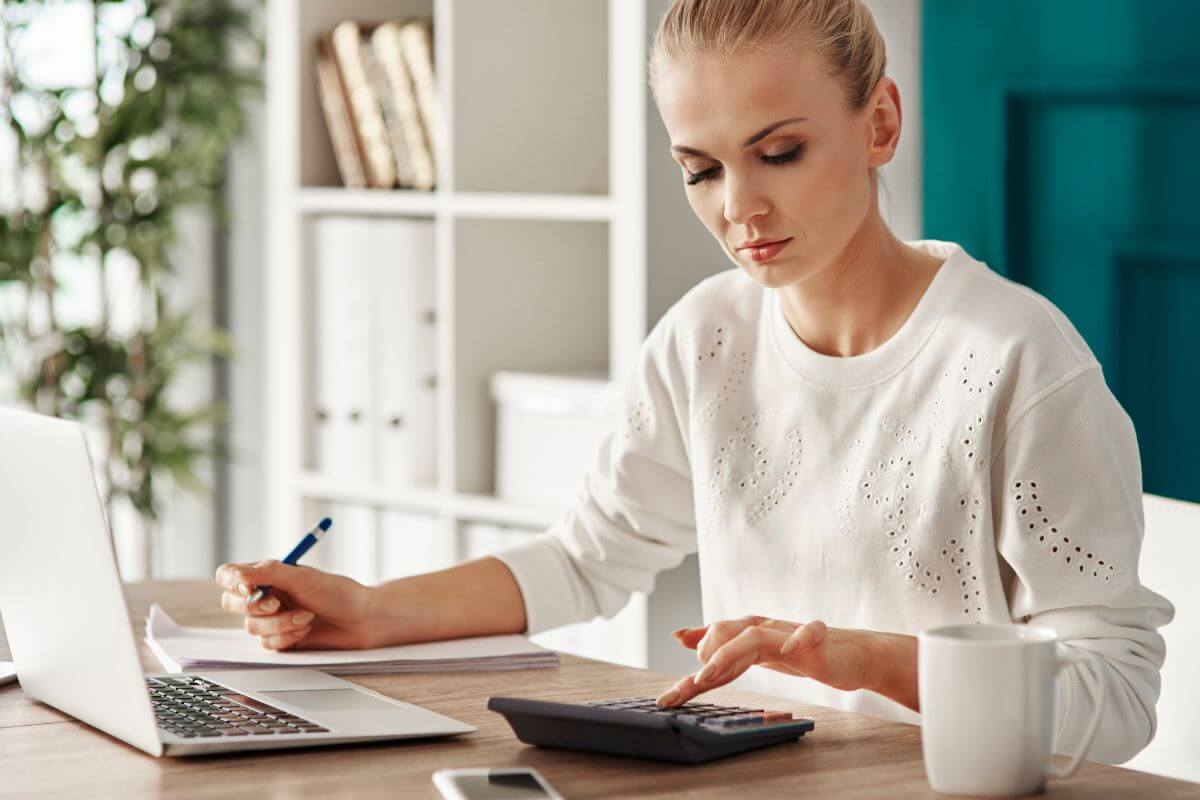 An image shows a woman budgeting.