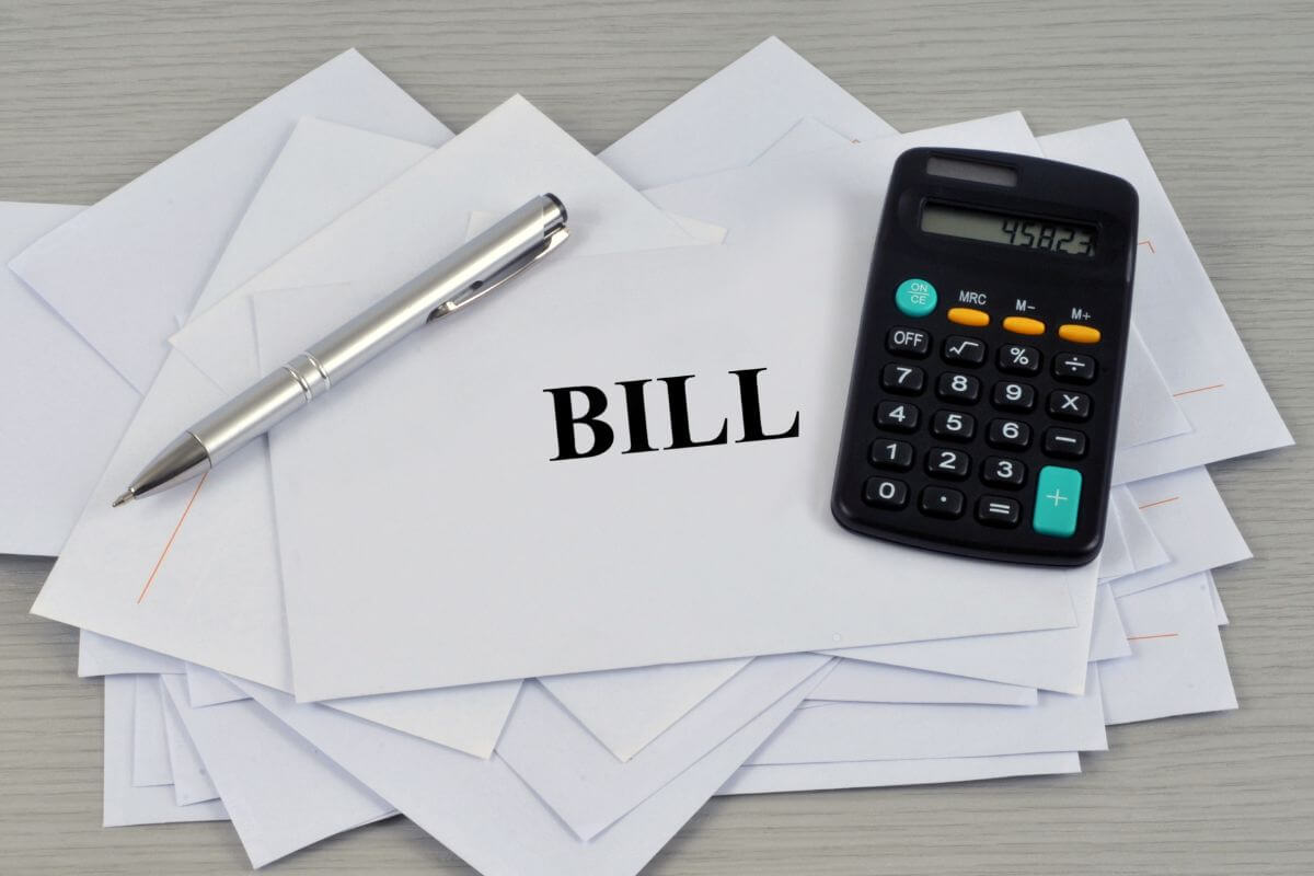 A picture of envelopes with bill wording and a calculator.