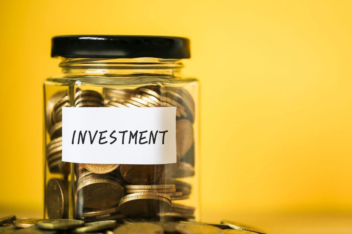 A picture shows a jar with money and an investment note.