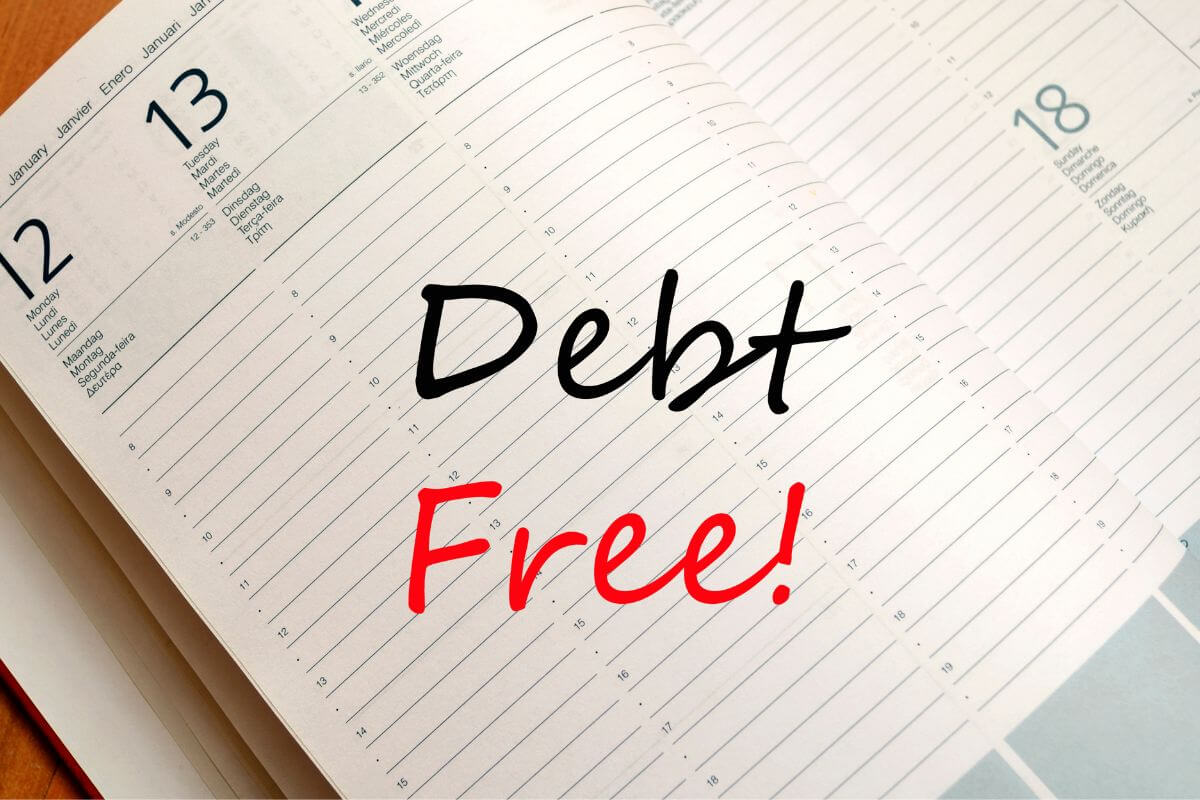 A picture shows a notebook with debt-free wording.