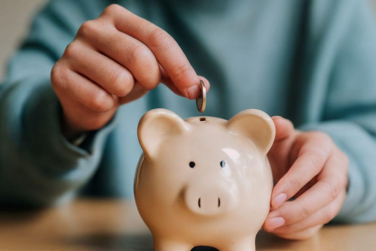 A picture of a man saving money in a piggy bank.