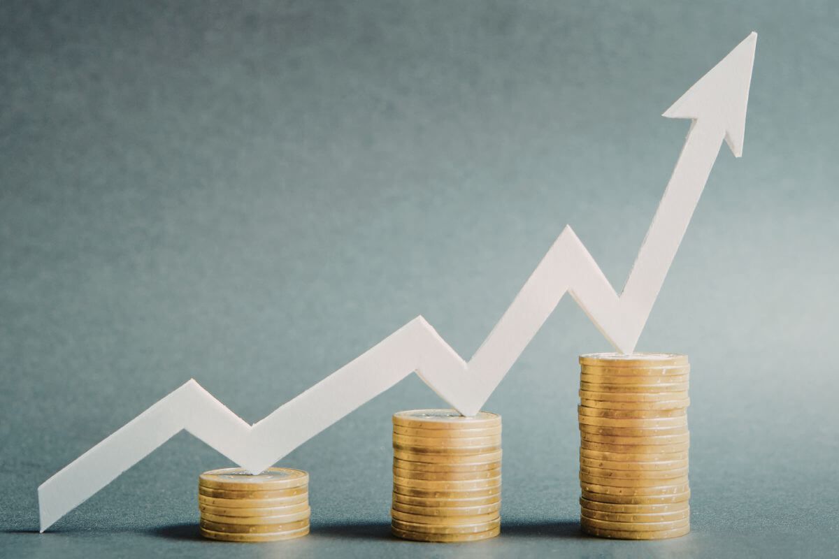 A picture shows stacks of coins and a rising arrow.