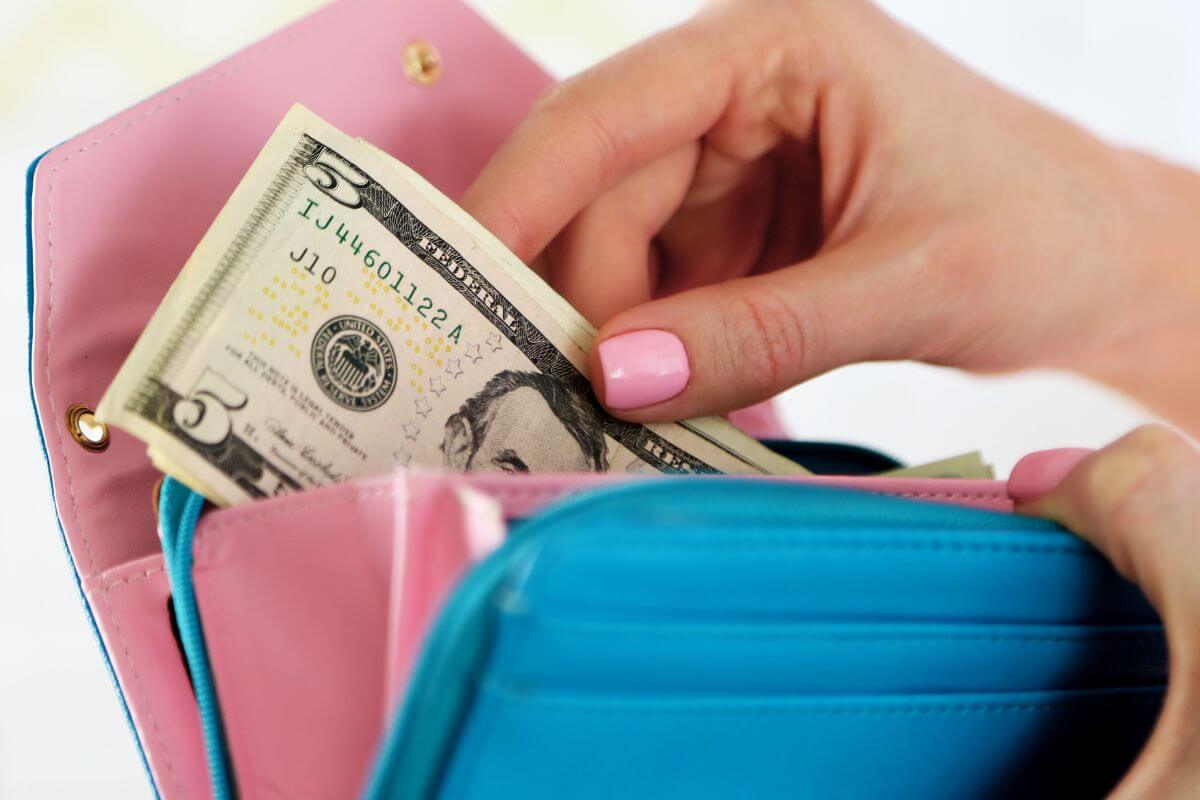 Une image d'une femme mettant son argent dans son portefeuille.
