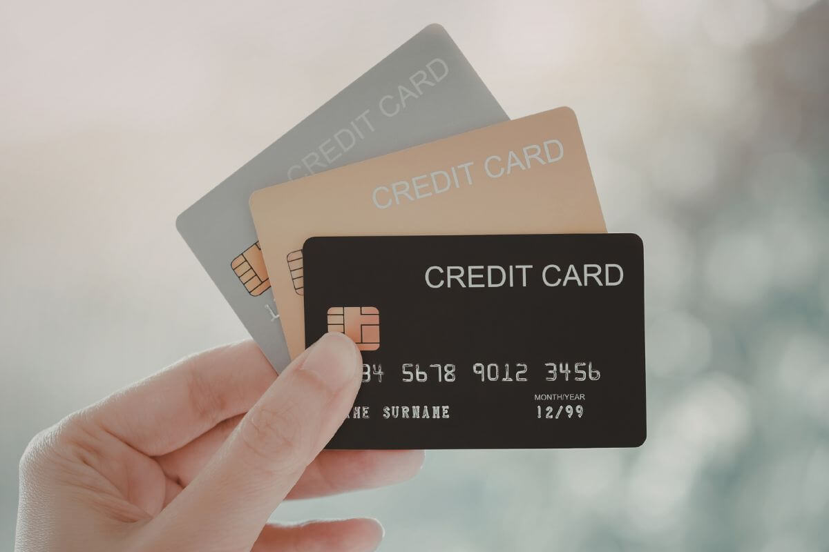 A picture shows a woman's hand holding credit cards.