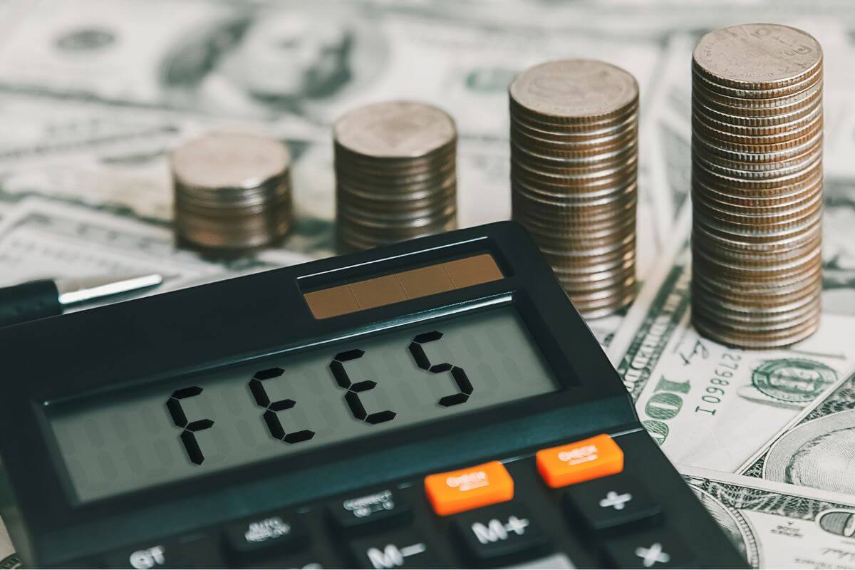 A picture shows stacks of coins and a calculator with the fees wording.