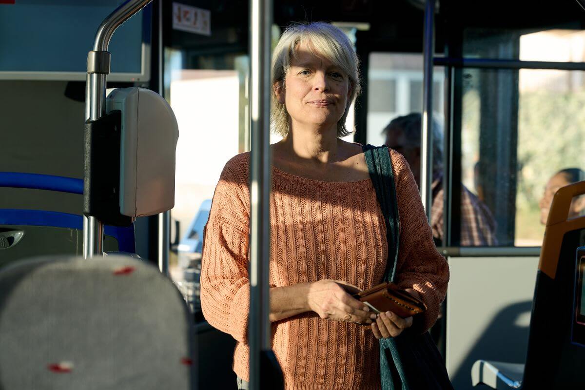 Uma foto de uma mulher idosa dentro do ônibus.