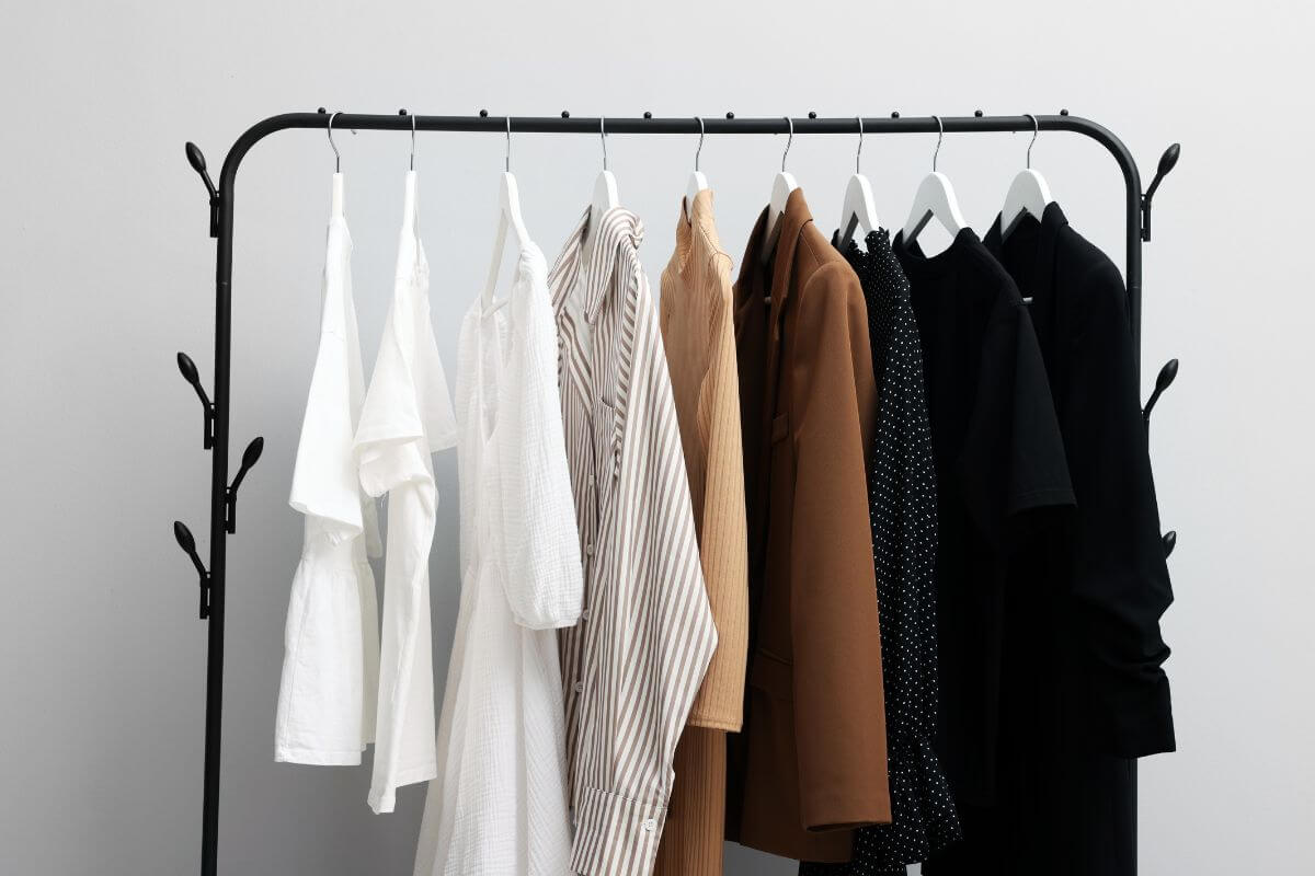 Uma imagem mostra roupas penduradas em um cabideiro.