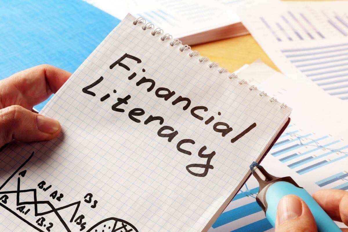 A picture shows a notebook with financial literacy wording.