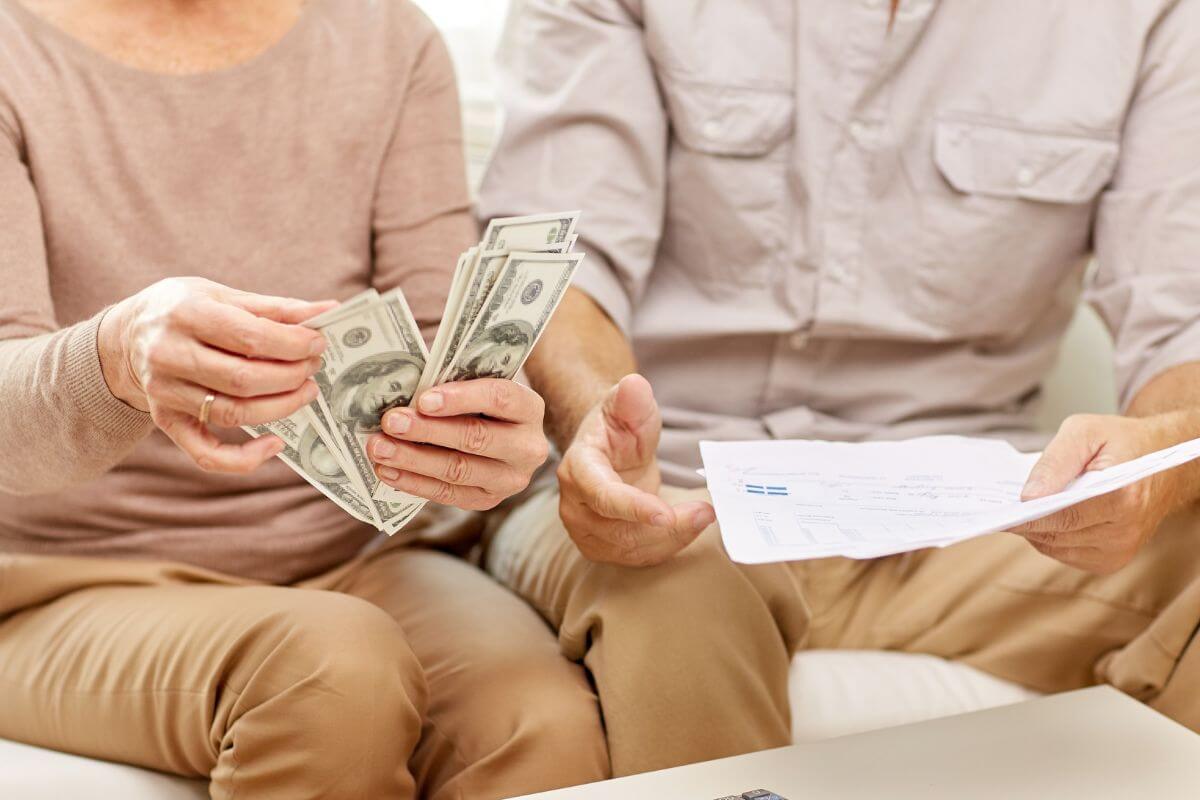 Uma foto mostra um casal de idosos contando dinheiro.