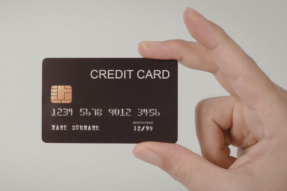 A picture shows a woman's hand holding a credit card.